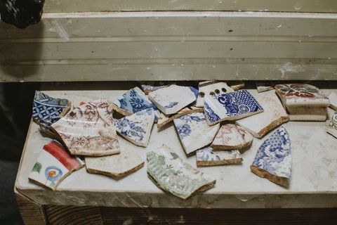 Porcelain. About twenty fragments of porcelain are painted blue, moss green, brown, or other colours.