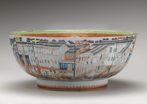 Porcelain. A wide bowl sits on a low, straight-sided foot. The outside of the bowl is painted with buildings lining a street with people.