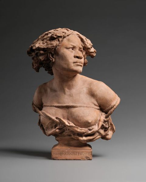 Sculpture. The head, shoulders, and chest of a Black woman are sculpted from terracotta. In this view, her shoulders square towards us, and she looks off to our right. Ropes bind her chest above and below one bare breast and her upper arms.